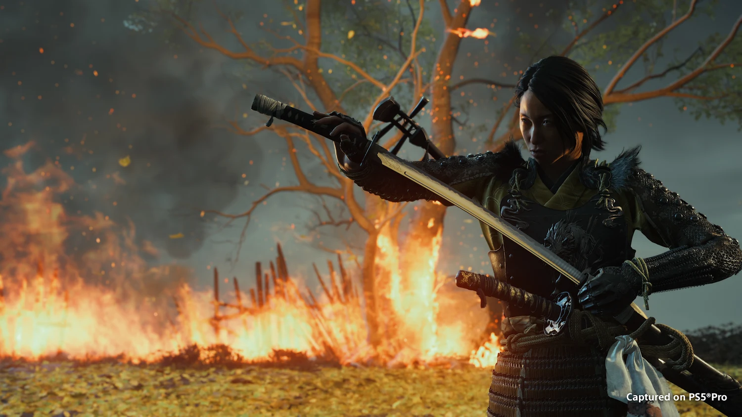 Atsu drawing a bow beside a burning field in an official Ghost of Yōtei screenshot