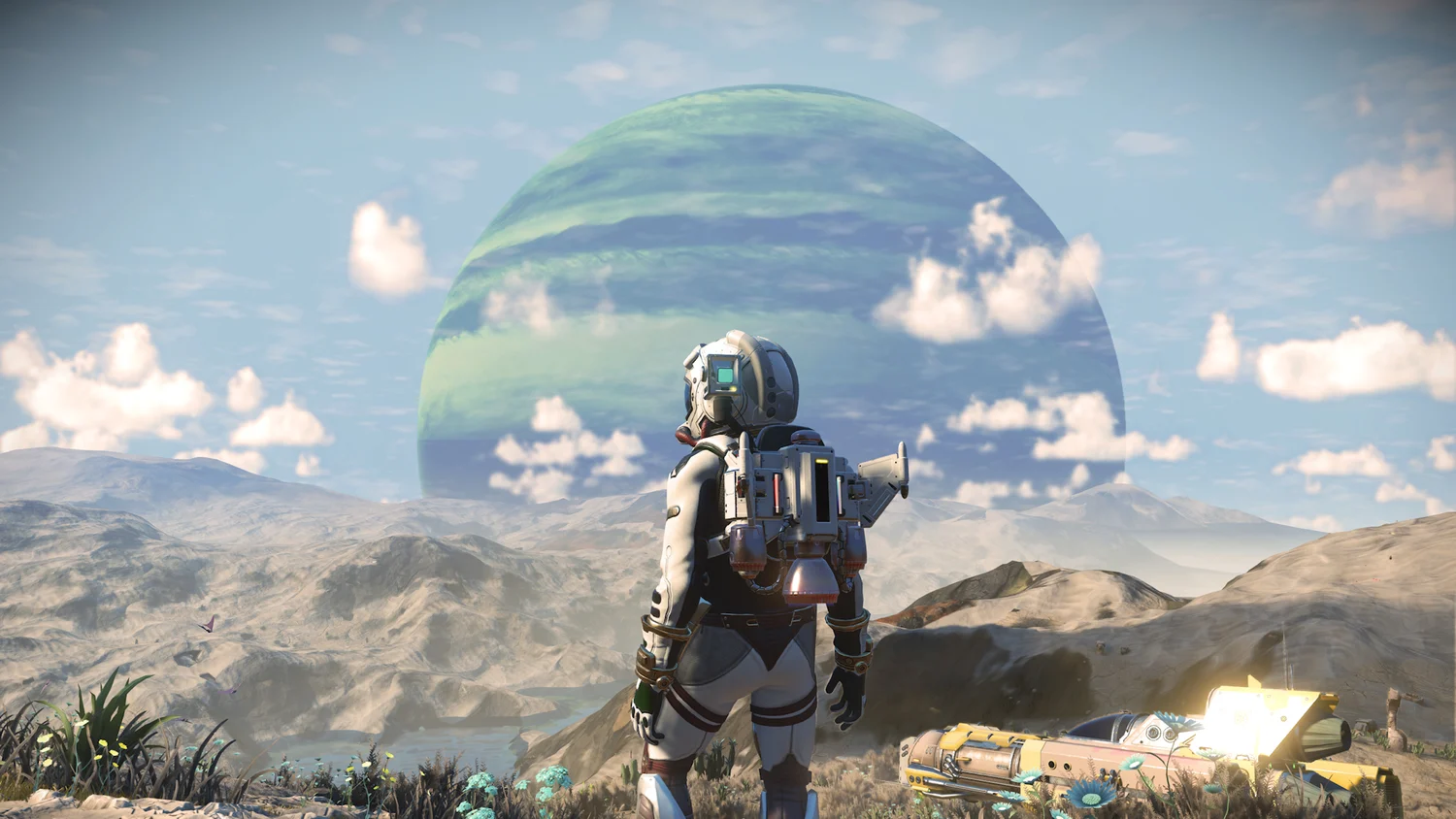 Traveller overlooking a pale No Man's Sky landscape and ringed planet