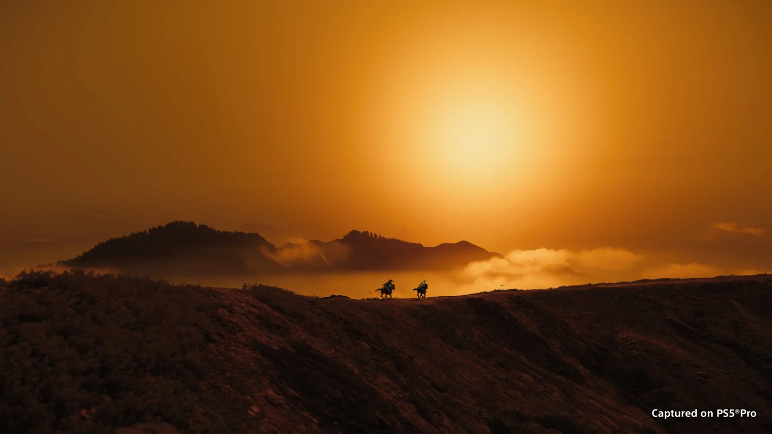 Mountain ridges beneath an orange sun