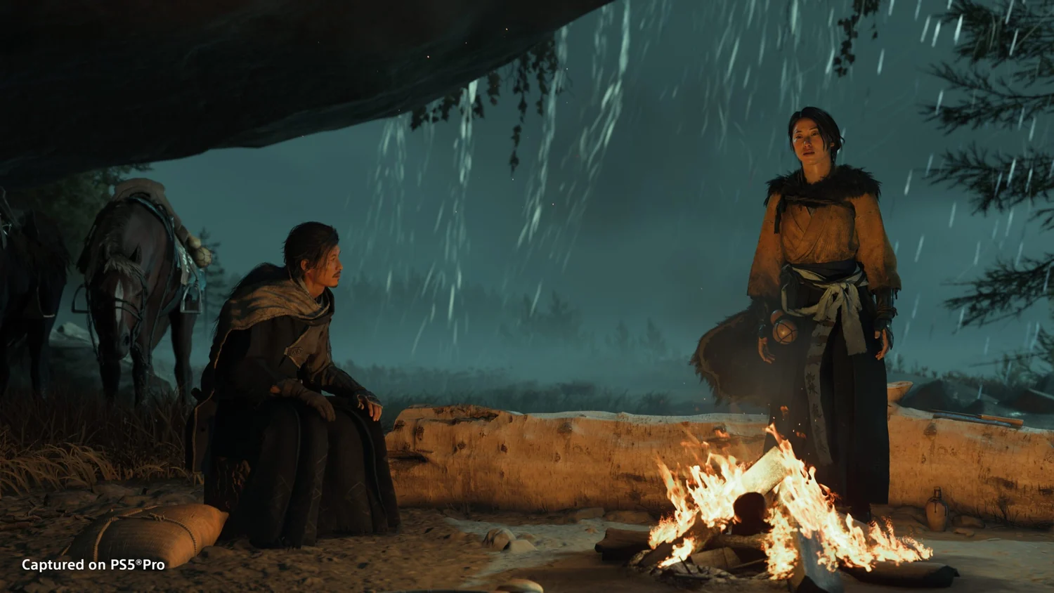 Two people beside a campfire